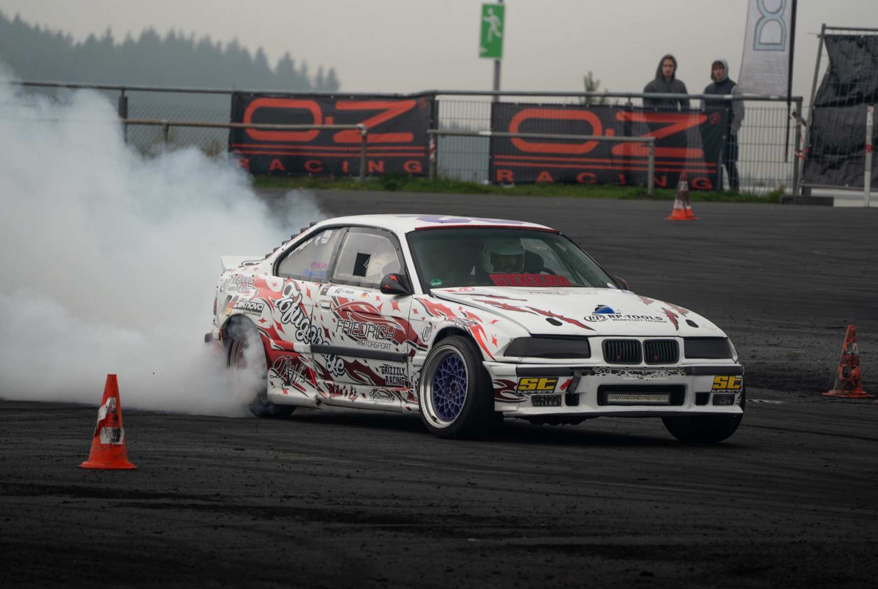 Driftender BMW E36 mit rauchenden Reifen auf der Rennstrecke