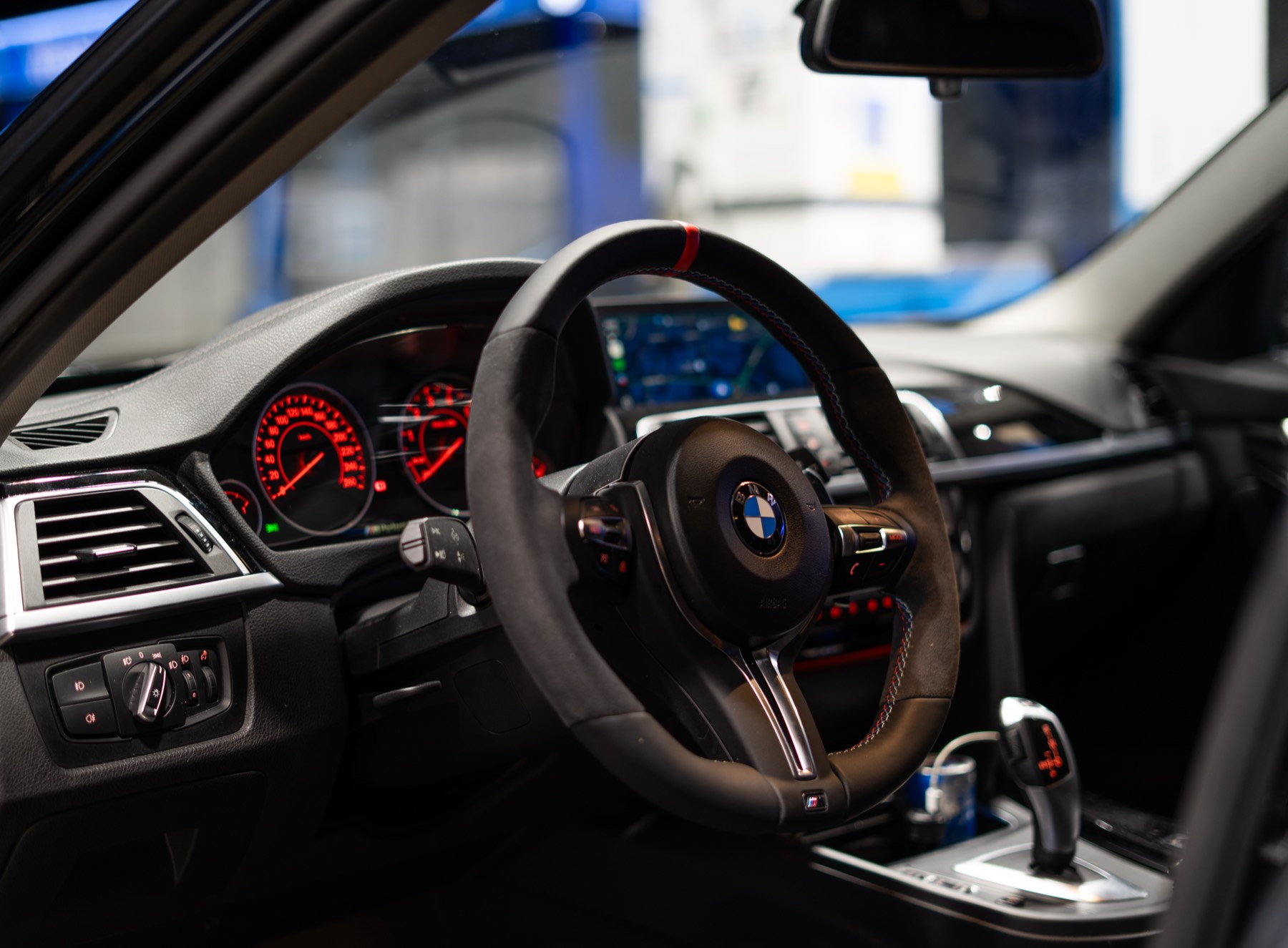 Cockpit eines BMW M mit rot beleuchteten Anzeigen