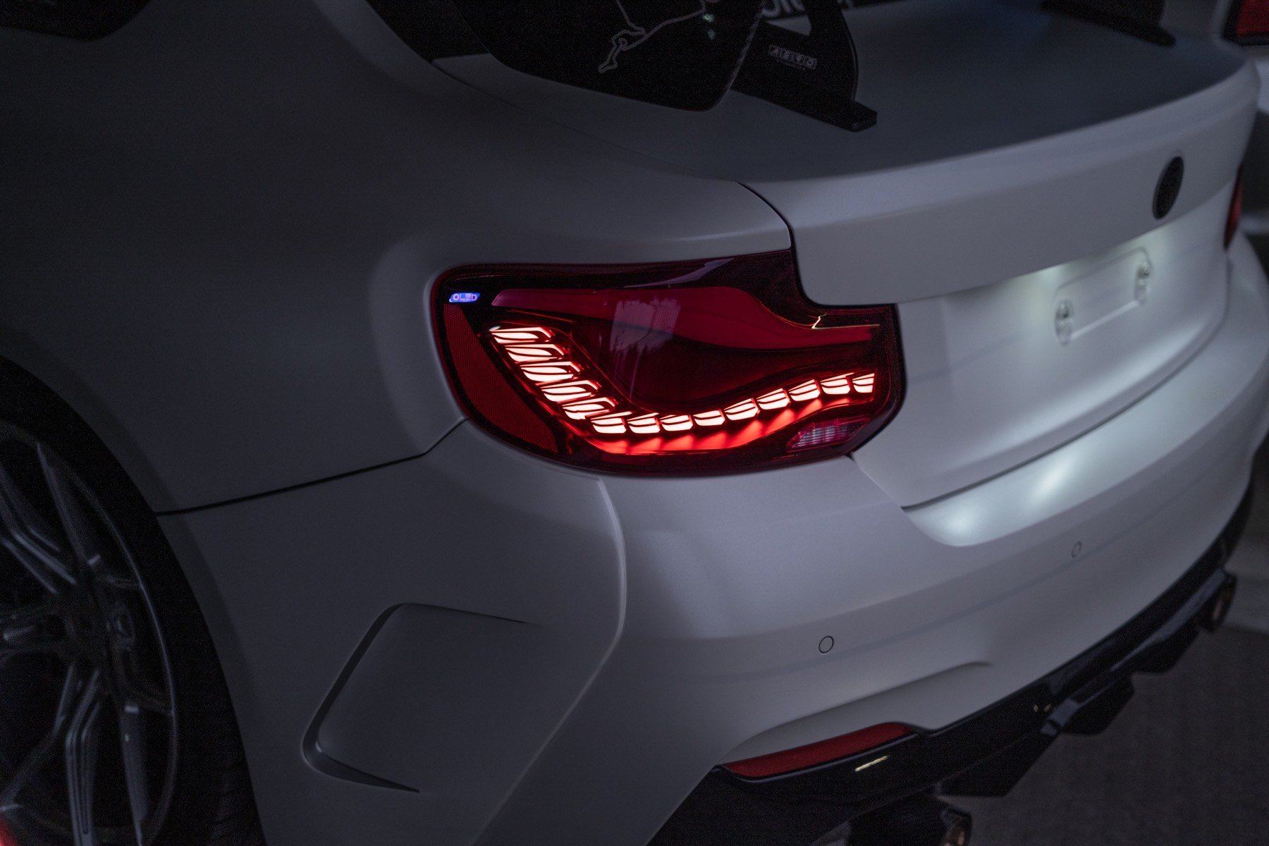 Leuchtendes Rücklicht des weißen BMW M240i Manhart