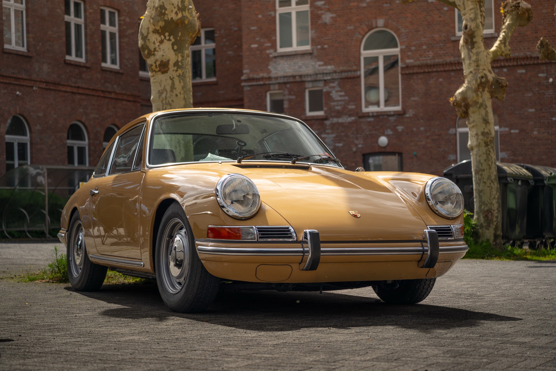 Beiger Porsche 912 vor einem Backsteingebäude