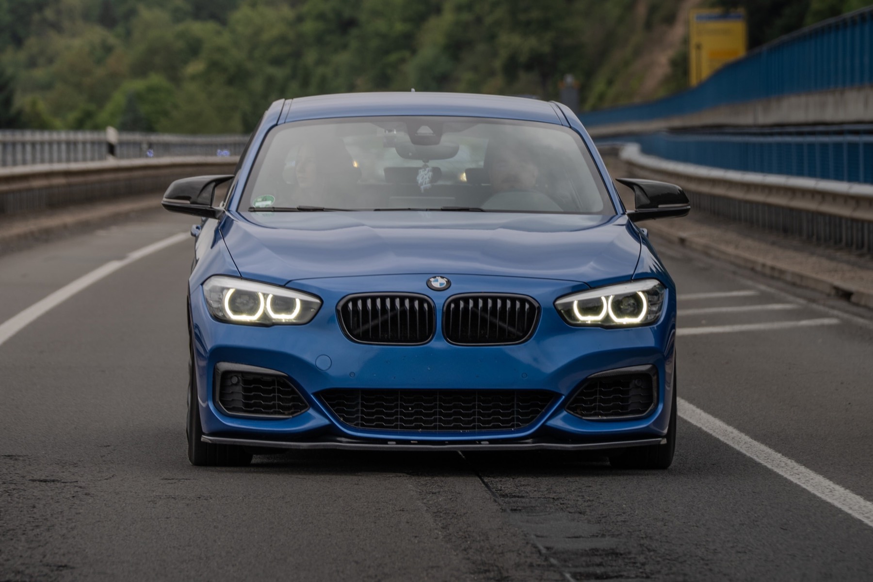 Blauer BMW M140i in Fahrt auf einer Landstraße